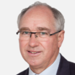 James Scruby A headshot of a man with dark silver hair, wearing glasses